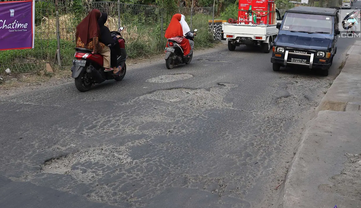 Lalu lalang kendaraan saat melintasi jalan berlubang di kawasan Gas Alam, Depok, Jawa Barat, Kamis (4/10). Kondisi jalan rusak di kawasan tersebut mengganggu aktivitas warga. (Liputan6.com/Immanuel Antonius)