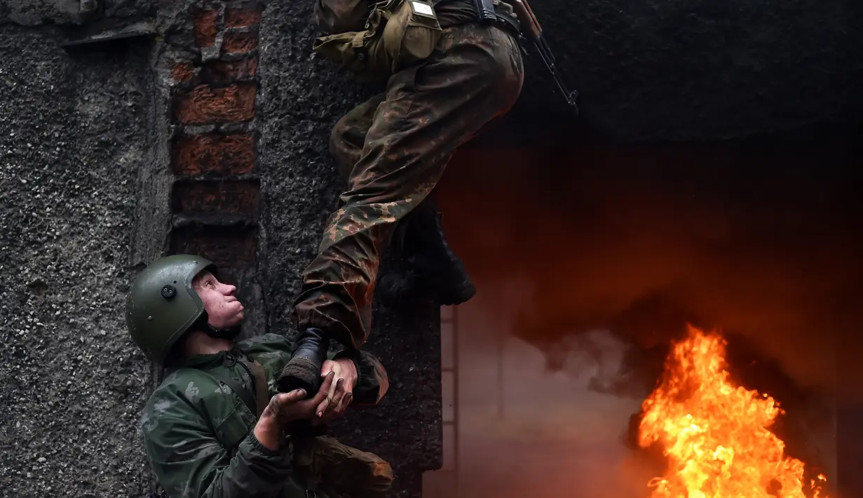 Aksi Tentara Kementerian Dalam Negeri Belarus dalam ujian kualifikasi memperoleh 'Madder Beret' di desa Volovshchina, Minsk, Selasa (23/10). Madder Beret, simbol bergengsi atas pencapaian tertinggi dalam pelatihan tempur Belarus. (Sergei GAPON/AFP)