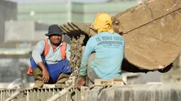 Pekerja dibantu alat berat melakukan pengecoran site pile normalisasi kali Ciliwung, Jakarta, Jumat (13/1). Meski warga Bukit Duri memenangkan gugatan di PTUN Jaksel, proyek normalisasi sungai Ciliwung tetap berlanjut. (Liputan6.com/Yoppy Renato)