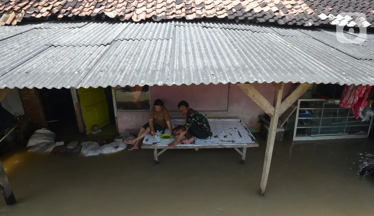 Aktivitas warga terdampak banjir di Desa Sindangsari, Kabupaten Bekasi, Jawa Barat, Rabu (24/2/2021). Sebagian rumah warga masih terendam banjir yang disebabkan jebolnya tanggul Sungai Citarum dan luapan Sungai Ciherang. (merdeka.com/Imam Buhori)