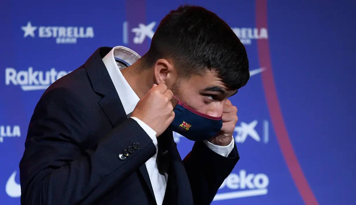 Penyerang baru Barcelona Pedri mengenakan masker selama presentasi resminya di stadion Camp Nou di Barcelona (20/8/2020). Pedri bermain di posisi winger kiri saat di Las Palmas. (AFP/Josep Lago)