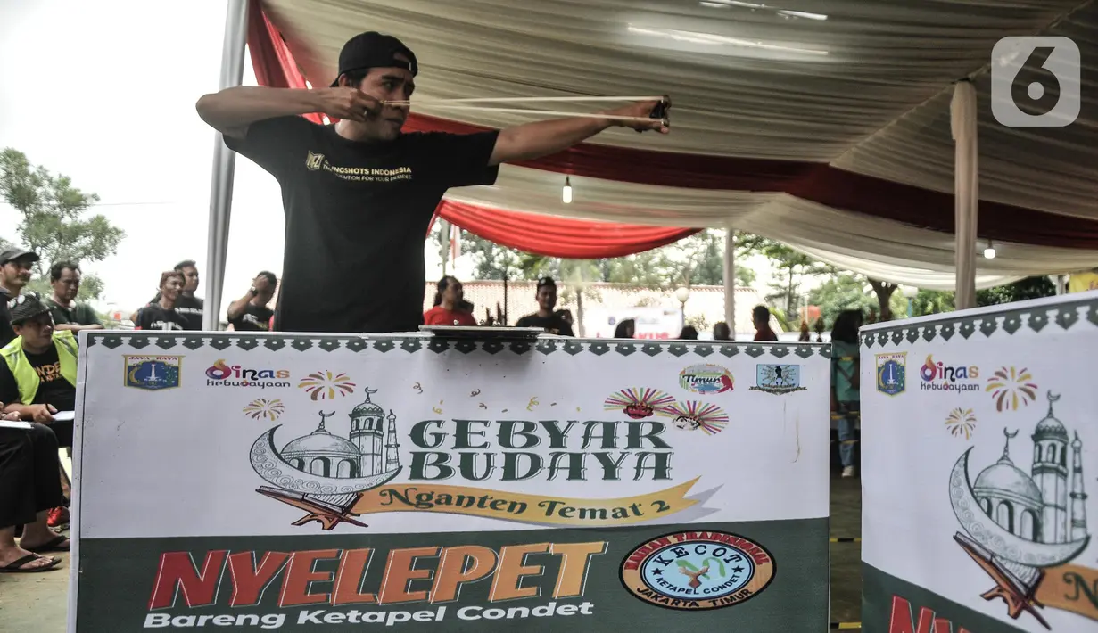 Peserta mengikuti lomba katapel saat Gebyar Budaya Nganten Temat II di RPTRA Dahlia, Kramat Jati, Jakarta Timur, Minggu (26/6/2022). Lomba katapel itu dalam rangka memeriahkan Gebyar Budaya Nganten Temat yang merupakan rangkaian dari perayaan HUT ke-495 DKI Jakarta. (merdeka.com/Iqbal S Nugroho)