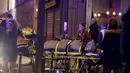 Petugas mengevakuasi korban yang tewas dari penembakan dan bom bunuh diri yang dilakukan teroris di Paris, Perancis, Jumat (13/11/2015). Dikabarkan ada 140 orang tewas dalam aksi teroris tersebut. (Reuters)