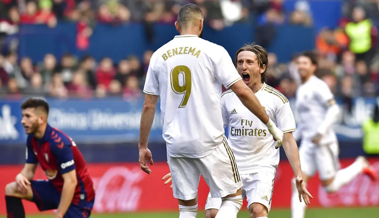 Pemain Real Madrid, Luka Modric bersama Karim Benzema merayakan gol ke gawang Osasuna pada laga La Liga di Stadion El Sadar, Minggu (9/2/2020). Real Madrid menang 4-1 atas Osasuna. (AP/Alvaro Barrientos)