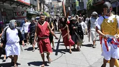 Seorang aktor yang berperan dalam sebuah drama jalanan sebagai Yesus membawa salib kayu saat peragaan penderitaan dan penyaliban pada Pekan Suci di Manila pada 28 Maret 2024. (Ted ALJIBE/AFP)