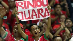 Suporter membentangkan tulisan Rindu Juara jelang menyaksikan laga final pertama Piala AFF 2016 antara Indonesia melawan Thailand di Stadion Pakansari, Kab Bogor, Rabu (14/12). Indonesia unggul 2-1 atas Thailand. (Liputan6.com/Helmi Fithriansyah)
