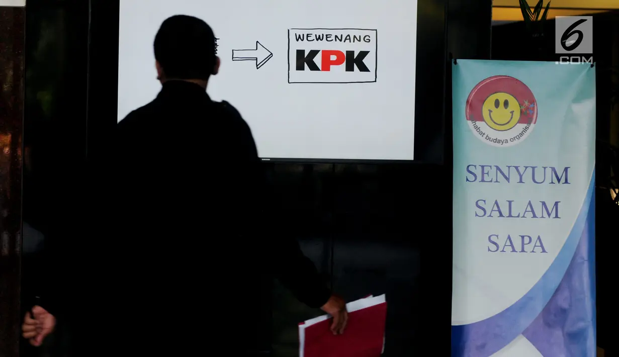 Seorang petugas berjalan melewati layar monitor yang menampilkan karikatur pemberantasan korupsi di lobi Gedung KPK, Jakarta, Selasa (20/3). Karikatur tersebut sebagai contoh proses pencegahan korupsi sejak dini. (Merdeka.com/Dwi Narwoko)