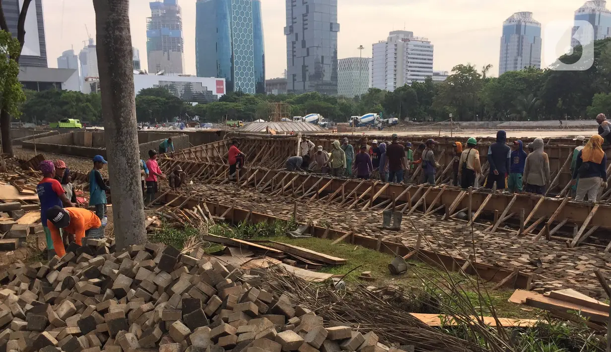Pekerja menyelesaikan pembangunan proyek revitalisasi Taman Monumen Nasional (Monas) di Jakarta, Sabtu (18/1/2020). Nantinya, Taman Monas bakal dilengkapi tempat duduk semi teater hingga kolam air dengan teknologi pencahayaan pada malam hari. (Liputan6.com/Immanuel Antonius)