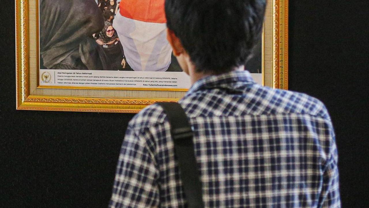 Seorang pengunjung mengamati salah satu karya fotografi dalam pameran Foto Parlemen Warna Warni ke XIII/2023 di Gedung Nusantara II, Jakarta, Rabu (12/7/2023).