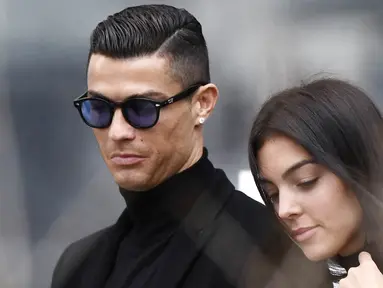 Cristiano Ronaldo bersama kekasihnya, Georgina Rodriguez, meninggalkan kantor pengadilan usai menghadiri sidang penggelapan pajak di Madrid, Spanyol (22/2/2019). (AFP/Oscar Del Pozo)