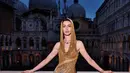 Anne Hathaway mengenakan sequined hooded gown berwarna emas dari koleksi FW23 Atelier Versace saat menghadiri Bulgari's jewelry show di Venice, Italia. [Twitter]