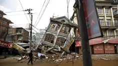 Foto yang diambil pada 1 Mei 2015 menunjukkan warga berjalan di dekat rumah yang runtuh setelah gempa 7,8 SR di Kathmandu. Setahun yang lalu, Nepal mengalami gempa terburuk dalam sejarah selama 80 tahun bencana di kawasan itu. (REUTERS/Navesh Chitrakar)