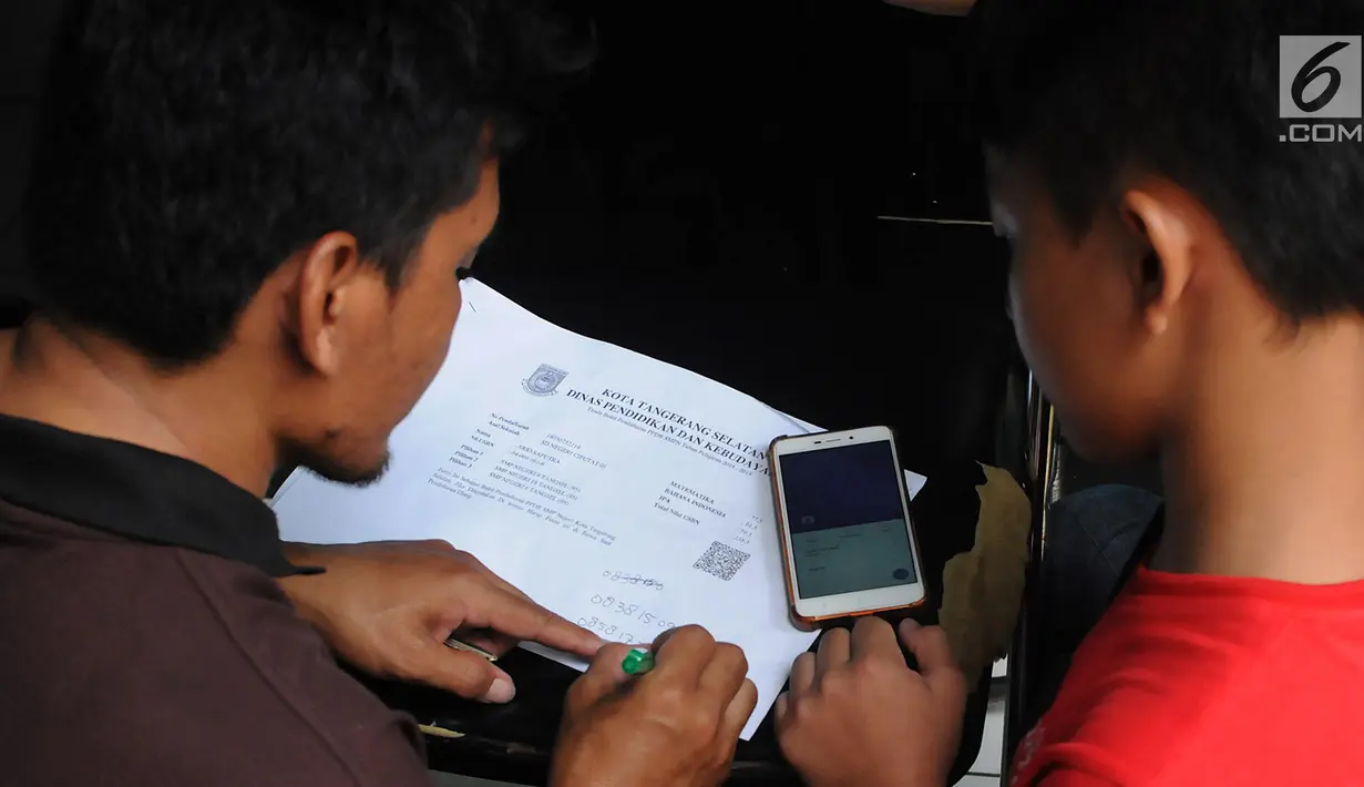 Orang tua wali murid menulis tanda bukti pendaftaran PPDB di posko SMP 11 di Rawa Buntu, Serpong, Tangsel, Jumat (13/07). Mereka protes karena tidak bisa mengetahui kelanjutan hasil pendaftaran putra-putrinya lewat situs PPDB. (Merdeka.com/Arie Basuki)