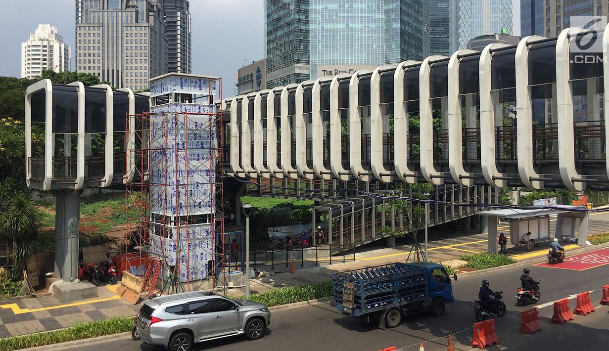 Suasana pembangunan lift pada jembatan penyeberangan orang di kawasan Senayan, Jakarta, Senin (13/5). Pembangunan lift pada tiga JPO yang berada di Jalan Sudirman itu bertujuan meningkatkan kenyamanan kepada warga dan ditargetkan rampung akhir bulan ini. (Liputan6.com/Immanuel Antonius)
