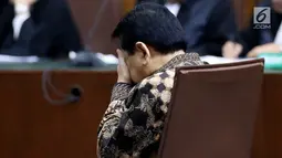 Terdakwa kasus korupsi E-KTP, Setya Novanto mengusap wajahnya ketika mendengarkan pembacaan sela pada sidang lanjutan di Pengadilan Tipikor, Jakarta, Kamis (4/1). Majelis Hakim memutuskan kasus korupsi E-KTP dilanjutkan. (Liputan6.com/Johan Tallo)