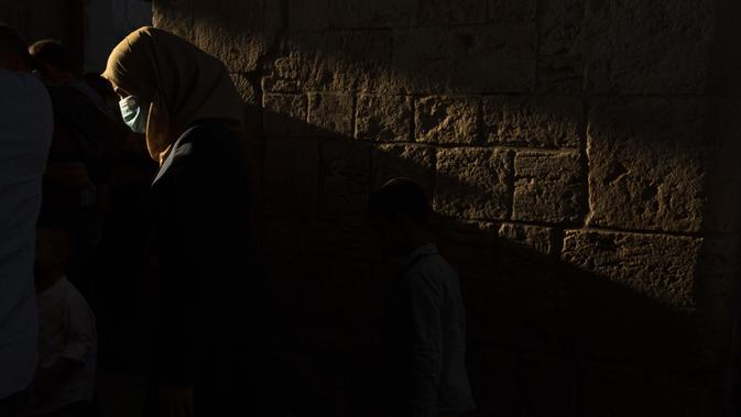 Seorang perempuan mengenakan masker untuk mencegah penyebaran COVID-19 usai salat Idul Adha di Kota Tua Yerusalem pada 31 Juli 2020. Perayaan Idul Adha agak tenang tahun ini karena virus corona dan langkah-langkah untuk membatasi penyebarannya. (AP Photo/Maya Alleruzzo)