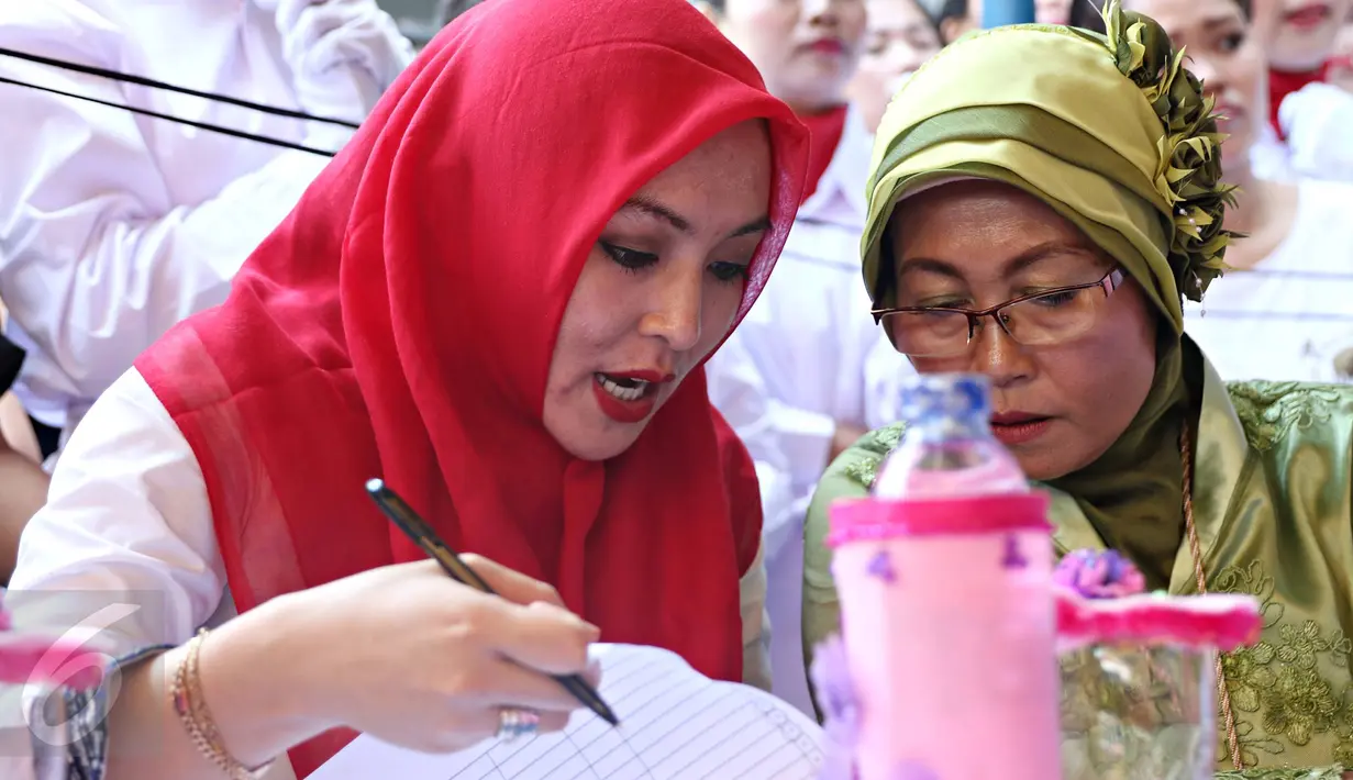 Terpidana kasus suap wisma atlet Angelina Sondakh (kiri) saat berdiskusi dengan juri lainnya di Rutan Pondok Bambu, Jakarta, (21/4). Dengan kenakan Hijab merah, Angelina tampak mempesona. (Liputan6.com/Immanuel Antonius)