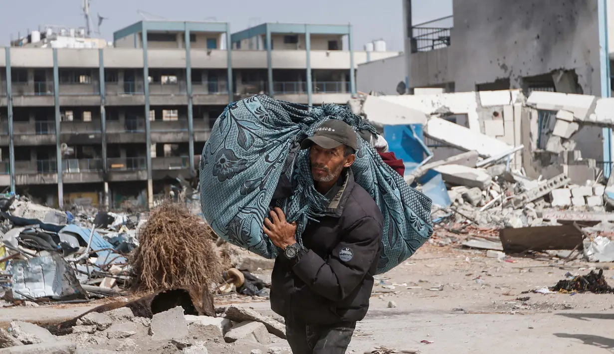 Seorang warga Palestina membawa barang-barangnya setelah mengunjungi rumah mereka yang hancur akibat serangan Israel di Khan Younis, Jalur Gaza, Rabu, 6 Maret 2024. (AP Photo/Mohammed Dahman)