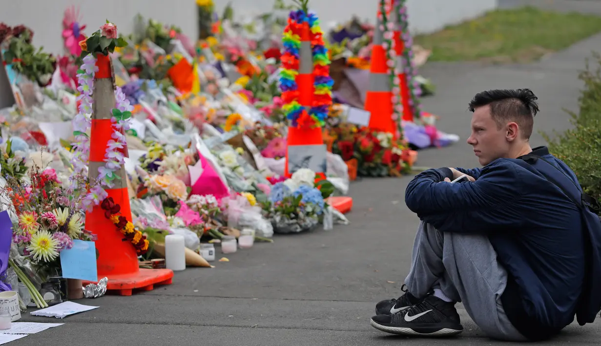 Seorang pelajar termenung saat menggelar mengenang korban penembakan di luar Masjid Al Noor, Christchurch, Selandia Baru, Senin (18/3). Penembakan tersebut merupakan serangan terburuk dalam sejarah Selandia Baru modern. (AP Photo/Vincent Yu)