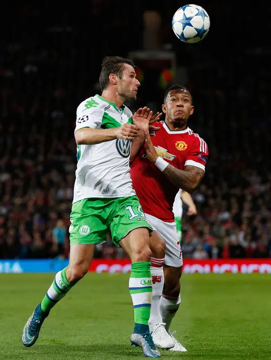 Penyerang MU, Memphis Depay (kanan) berebut bola udara dengan gelandang Wolfsburg, Christian Trasch pada laga Liga Champions di Stadion Old Trafford, Inggris, Kamis (1/10/2015). MU menang atas Wolfsburg dengan skor 2-1. (Reuters/Andrew Yates)
