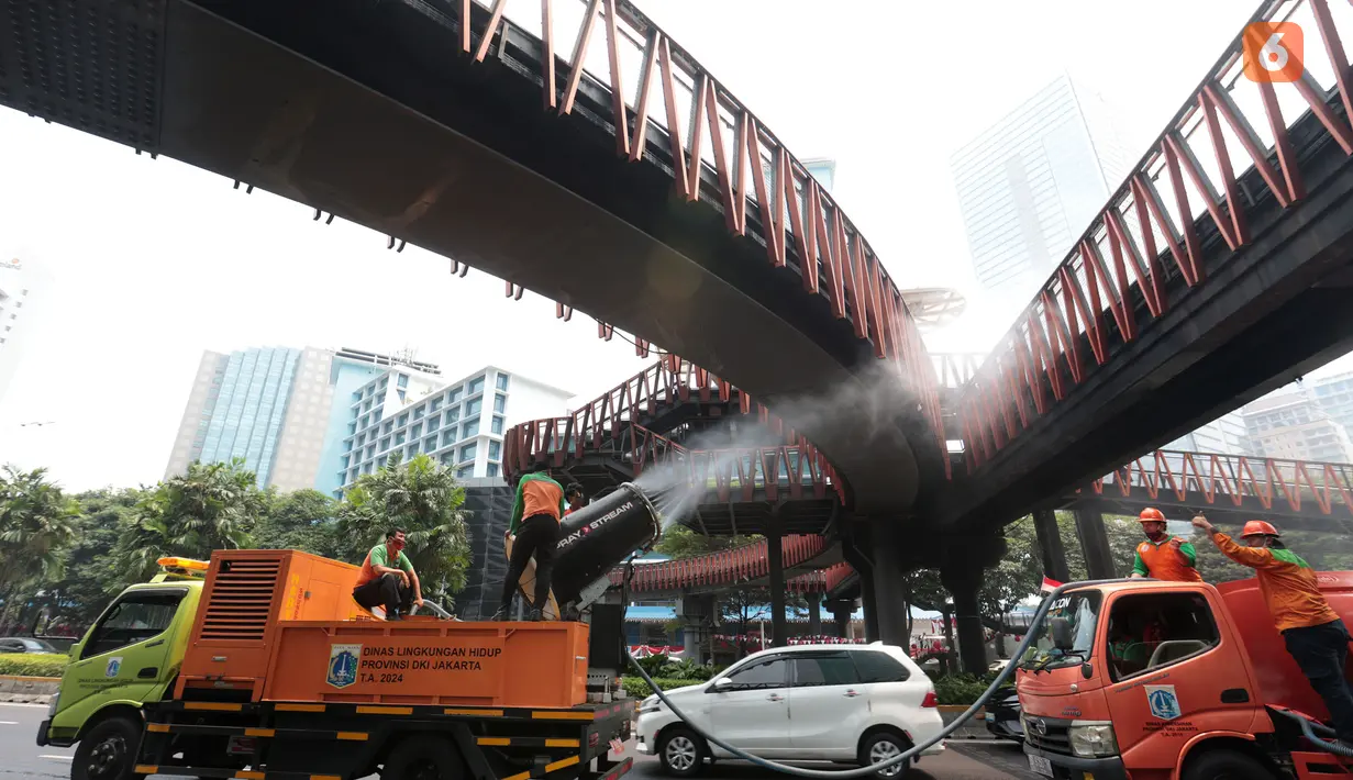 Petugas menyemprotkan air bertekanan tinggi ke permukaan jalan dalam operasi water mist untuk mengendalikan partikel debu akibat sebaran abu vulkanik Gunung Anak Krakatau di Jakarta. (KLY/Budy Santoso)