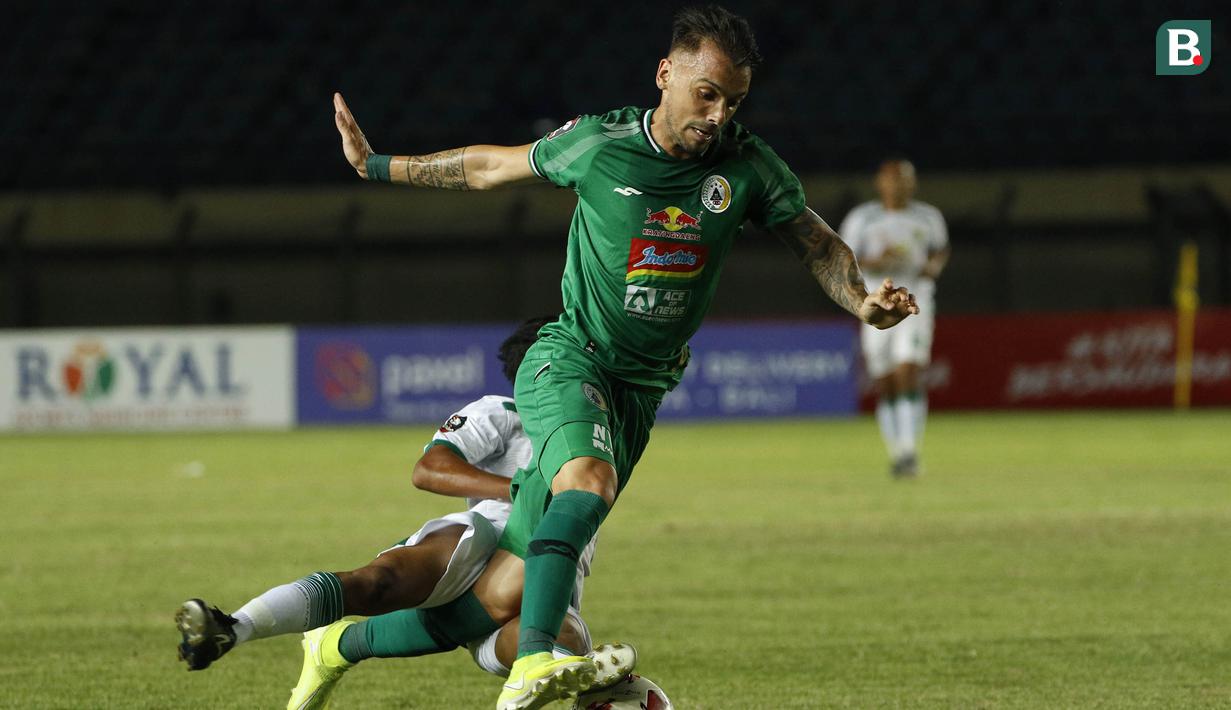 Striker PS Sleman, Velez Nicolas Leandro (depan) dilanggar gelandang Persebaya Surabaya, Dicky Kurniawan Arifin dalam laga Grup C Piala Menpora 2021 di Stadion Si Jalak Harupat, Bandung, Rabu (7/4/2021). (Bola.com/Ikhwan Yanuar)