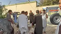 Warga Afghanistan membawa jasad korban ke ambulans setelah serangan bom di sebuah masjid di Kunduz. (AFP)