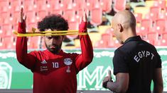 Pemain timnas Mesir Mohamed Salah dibantu tim kesehatan melatih bahunya yang cedera saat pelatihan di stadion Akhmat Arena di Grozny (12/6). Timnas Mesir berada di grup bersama Uruguay, Arab Saudi dan Rusia. (AFP Photo/Karim Jaafar)