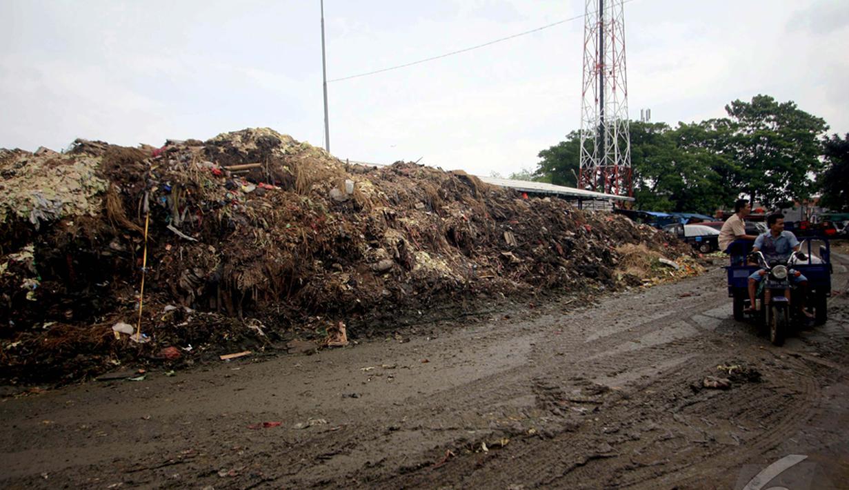Warga saat melintas di dekat gunungan sampah di Pasar Induk Kramat Jati, Jakarta, Kamis (8/1/2015). (Liputan6.com/Faizal Fanani)