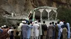 Orang-orang berdiri dan menyaksikan masjid yang rusak setelah serangan bom bunuh diri di dalam masjid pinggir jalan di distrik Khyber di provinsi Khyber Pakhtunkhwa, Pakistan, Selasa, 25 Juli 2023. (AP Photo/Muhammad Sajjad)