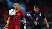 Duel pemain Vietnam, Que Ngoc Hai, dengan gelandang Timnas Thailand, Chanathip Songkrasin, saat kedua tim bertemu di kualifikasi Piala Dunia 2022 di Thammasat Stadium (5/9/2019).  (AFP/Chalinee Thirasupa)