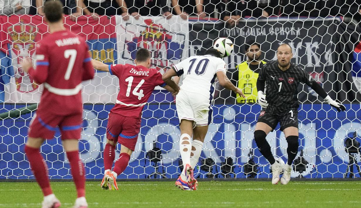 Pemain Inggris, Jude Bellingham, mencetak gol melalui tandukan kepala saat melawan Serbia pada laga Grup C Euro 2024 di Veltins Arena hari Senin (17/06/2024). (AP Photo/Thanassis Stavrakis)