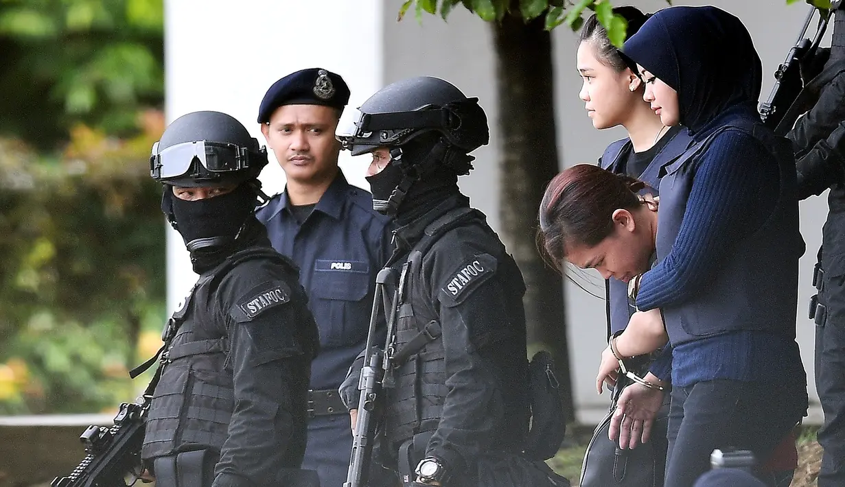 Terdakwa warga Indonesia, Siti Aisyah dikawal oleh polisi masuk ke Gedung Mahkamah Sepang, Selangor, Kamis (13/4). Sidang kedua kasus pembunuhan saudara pemimpin Korea Utara, Kim Jong-nam di bawah penjagaan ketat aparat keamanan. (MOHD RASFAN/AFP)