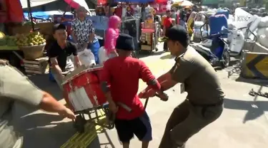 seorang pedagang kako lima (PKL) membuang dagangannya ke tengah jalan. Hal itu dilakukan menghindari razia yang dilakukan Satpol PP Kecamatan Tanah Abang