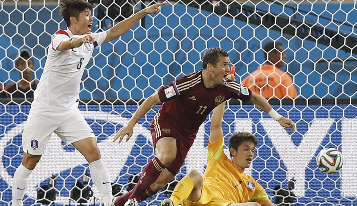 Pemain depan Rusia, Alexander Kerzhakov (tengah) berlari usai menjebol gawang Korea Selatan yang dikawal Ryong Jung Sung di babak penyisihan Piala Dunia 2014 Grup H, Pantanal Arena, Cuiaba, Brasil, (18/6/2014). (AFP PHOTO/Adrian Dennis) 