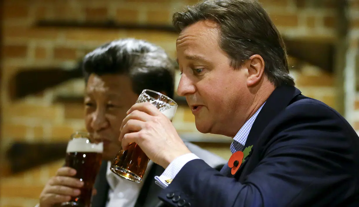 Perdana Menteri Inggris David Cameron (kanan) minum bir bersama Presiden China Xi Jinping di sebuah bar, Inggris, (22/10/2015). Di sela kunjungan ke Inggris, Presiden Cina Xi Jinping diajak PM David Cameron untuk minum bir. (REUTERS/Kirsty Wigglesworth)