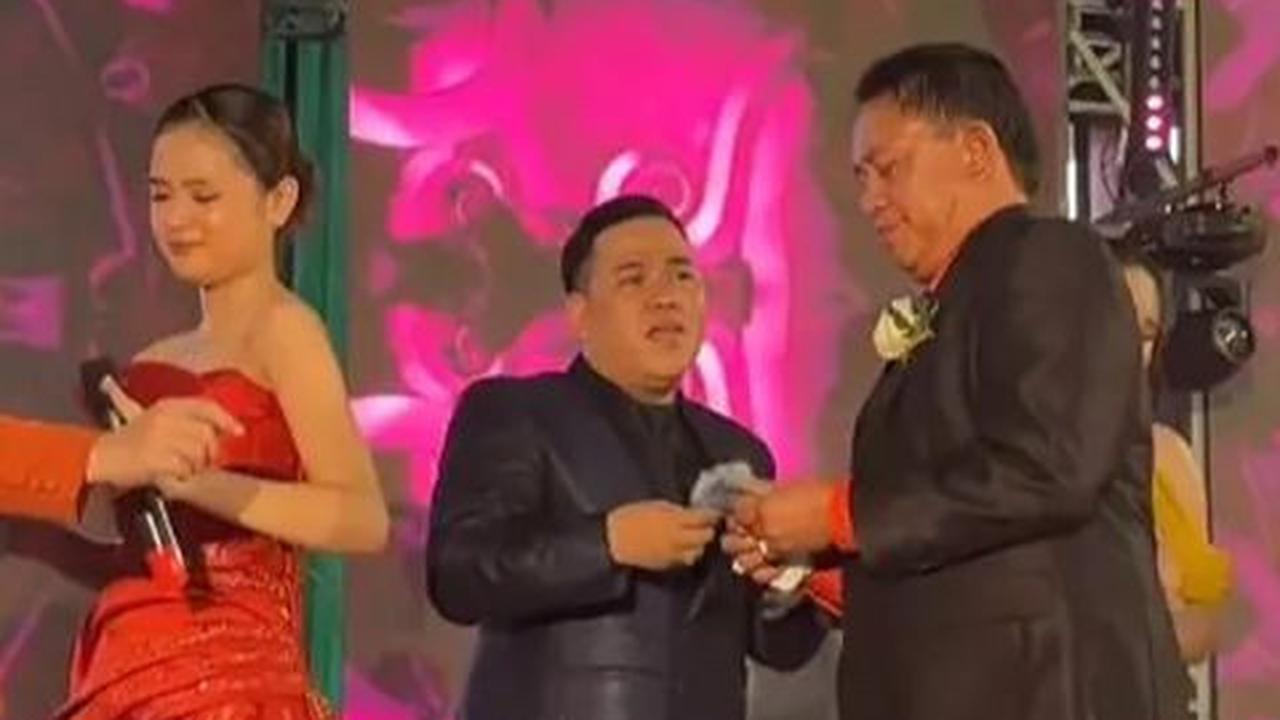 Tidak hanya membagikan uang kepada para tamu, Haji Alwi juga menunjukkan kasih sayangnya dengan menyawer istrinya sendiri di atas panggung saat sedang bernyanyi.