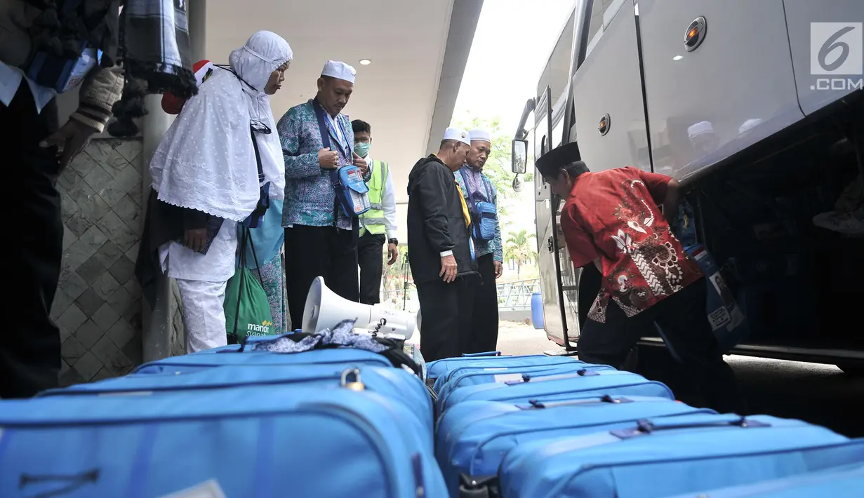 Panitia Penyelenggara Ibadah Haji (PPIH) membantu memindahkan koper milik jemaah haji kloter 2 saat tiba di Asrama Haji Pondok Gede, Rabu (29/8). (Merdeka.com/Iqbal S. Nugroho)