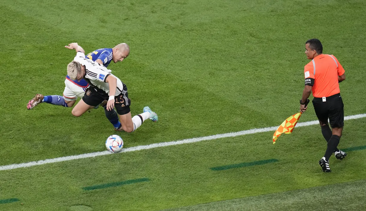 Penyerang Jepang, Daizen Maeda berebut bola dengan bek Jerman, Nico Schlotterbeck selama pertandingan grup E Piala Dunia 2022 Qatar di Stadion Internasional Khalifa di Doha, Qatar, Rabu (23/11/2022). Dengan kemenangan ini, Jepang untuk sementara berada di puncak klasemen. (AP Photo/Ricardo Mazalan)