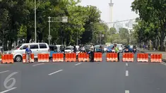 Petugas Satlantas melakukan penutupan Jalan Medan Merdeka menuju Istana Negara, Jakarta, Jumat (30/10). Berbagai antisipasi dilakukan jajaran kepolisian untuk mengamankan jalannya aksi demo ribuan buruh di depan Istana. (Liputan6.com/Yoppy Renato)