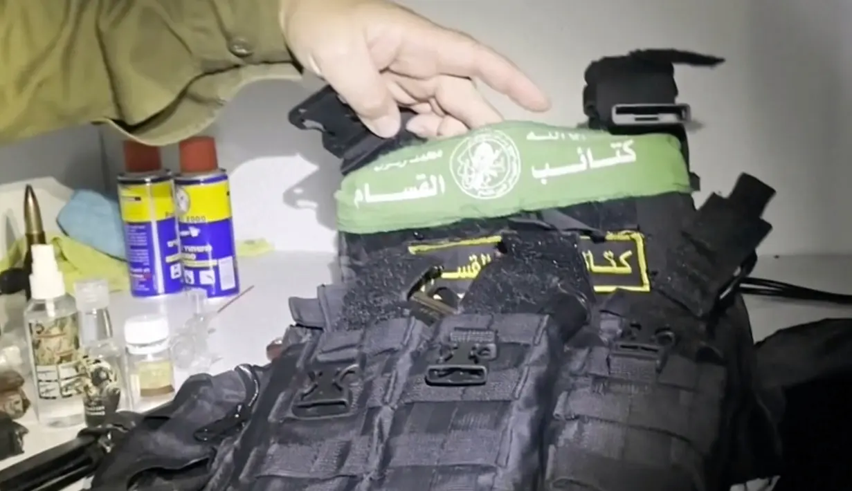Dalam gambar yang diambil dari video yang dirilis Pasukan Pertahanan Israel atau Israeli Defense Forces (IDF) pada Rabu (15/11/2023), Juru Bicara Militer Israel Letkol Jonathan Conricus menunjukkan rompi antipeluru dengan lambang Hamas yang ditemukan bersama senjata dari lemari medis pusat MRI RS Al-Shifa di Kota Gaza. (Israel Defense Forces via AP)