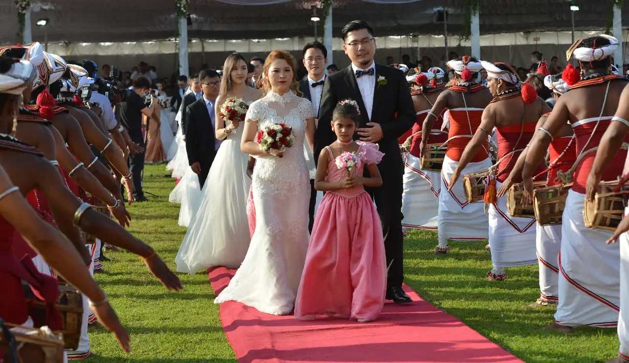 Sejumlah pasangan pengantin asal Tiongkok mengikuti upacara pernikahan massal di Kolombo, Sri Lanka (17/12). Acara nikah massal ini juga bertujuan untuk meningkatkan pariwisata di Sri Lanka. (AFP Photo/Ishara S. Kodikara)