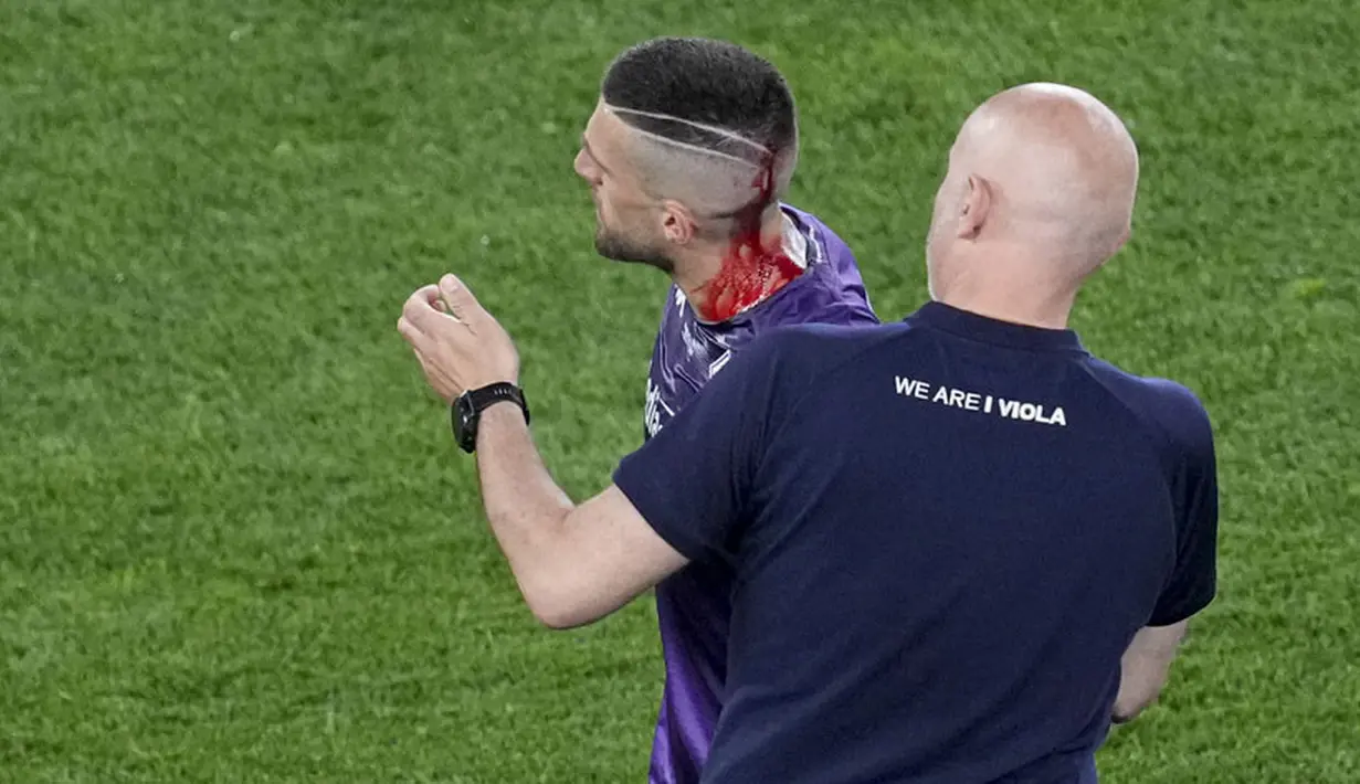 Darah mengalir di kepala pemain Fiorentina, Cristiano Biraghi, setelah insiden pelemparan benda dari tribun suporter West Ham United pada laga final UEFA Europa Conference League di Stadion Eden Arena, Kamis (8/6/2023). Fiorentina takluk dengan skor 1-2. (AP Photo/Darko Vojinovic)