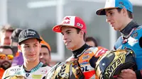 Pembalap MotoGP Marc Marquez (tengah) bersama pembalap Moto2 Alex Marquez (kanan) dan pembalap Moto3 Lorenzo Dalla Porta berdiri bersama di depan Valencia Motorcycle Grand Prix, Spanyol, Minggu (17/11/2019). Ketiganya sukses merebut gelar juara dunia tahun 2019. (AP Photo/Alberto Saiz)