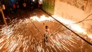 Seorang pemuda Palestina mengayunkan kembang api buatan sendiri, saat orang-orang merayakannya pada malam menjelang bulan suci Ramadan, di Kota Gaza (11/4/2021). (AFP Photo/Mohammed Abed)