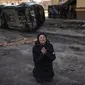 Tanya Nedashkivs'ka (57) berduka atas kematian suaminya YANG terbunuh di Bucha, di pinggiran Kiev, Ukraina, Senin, 4 April 2022. Perempuan itu berlutut di lumpur, tangannya terkepal dan wajahnya berubah sedih saat dia terisak-isak atas kematian suaminya. (AP Photo/Rodrigo Abd)