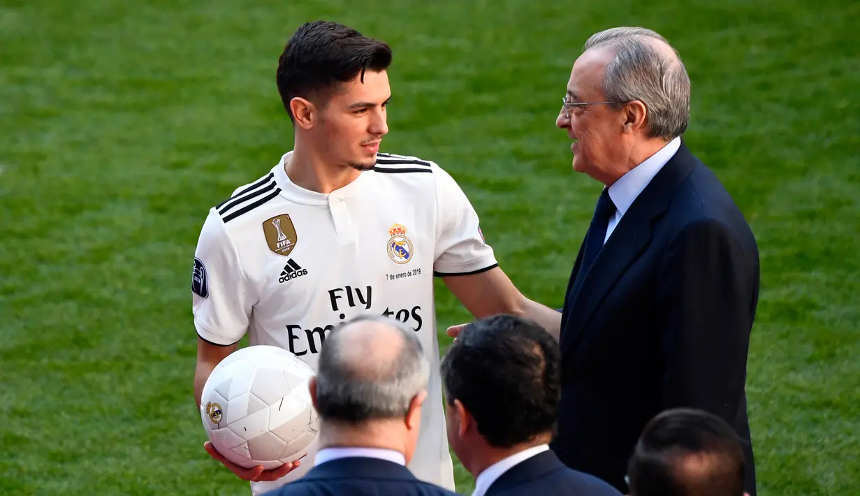 Pemain baru Real Madrid, Brahim Diaz berbincang dengan Presiden Florentino Perez saat perkenalan dirinya  di stadion Santiago Bernabeu  (7/1). Pemain 19 tahun ini dikontrak Real Madrid hingga 30 Juni 2025. (AFP Photo/Gabriel Bouys)