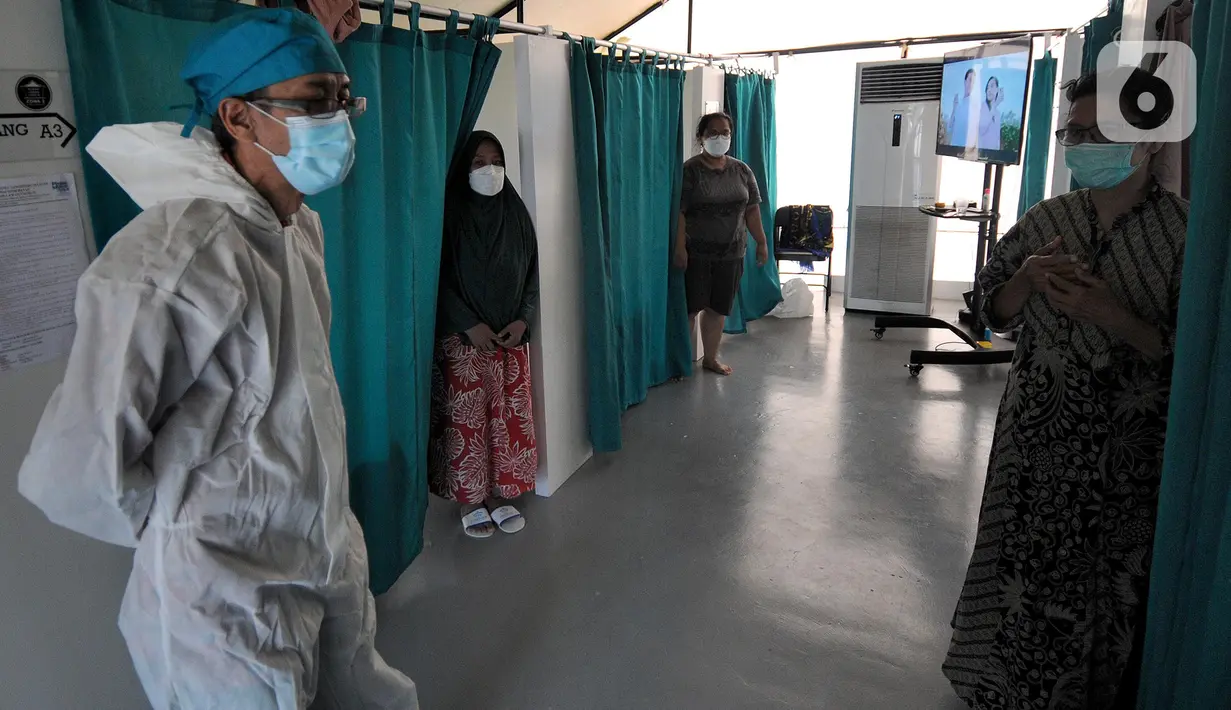 Koordinator RLC Kota Tangsel Suhara Manullang memeriksa kondisi pasien di Rumah Lawan Covid di Tangerang Sealatan, Kamis (5/8/2021). Dua pekan terakhir pasien Covid di RLC mengalami penurunan hingga 70 persen dari semula 300 pasien kini hanya 113 pasien. (merdeka.com/Arie Basuki)