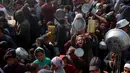 Warga, termasuk anak-anak pengungsi Palestina berkumpul untuk menerima bantuan makanan yang didistribusikan di Deir al-Balah, Jalur Gaza tengah pada 16 Januari 2025. (Eyad BABA/AFP)