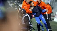 Petugas keamanan menangkap seorang suporter yang berhasil masuk ke lapangan Stadion Velodrome, Jumat (18/3/2016). Kejadian tersebut dipicu kekalahan Marseille atas Rennes dengan skor 2-5, dalam lanjutan Ligue 1 2015-2016.  (Reuters/Jean-Paul Pelissier 